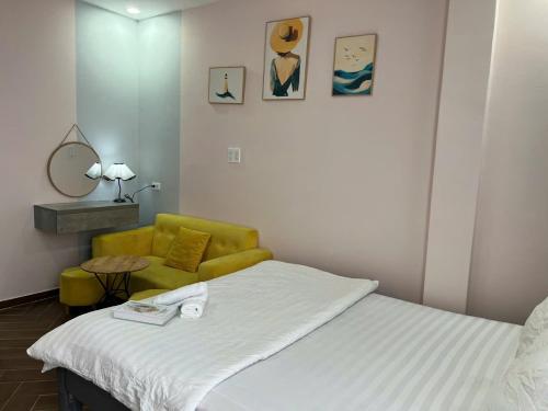 ein Schlafzimmer mit einem Bett und einem gelben Stuhl in der Unterkunft LALA HOUSE - CĂN HỘ Đà Lạt in Khu Chi Lăng
