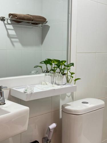 a bathroom with a toilet and a sink and a mirror at Hotel Insitu Garut Syariah in Garut