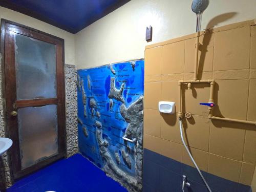 a bathroom with a shower with a painting on the wall at Islandfront El Nido in El Nido