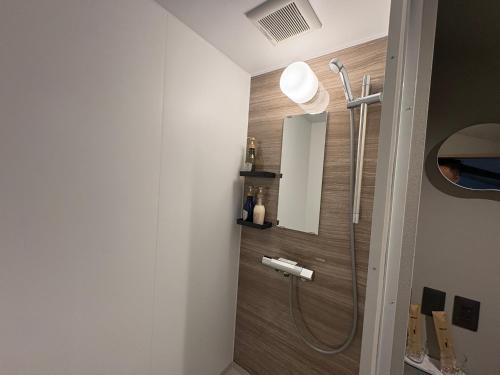 a bathroom with a shower with a wooden wall at Machiya inside Chomoji temple, near Gion, downtown in Shimmachidōri