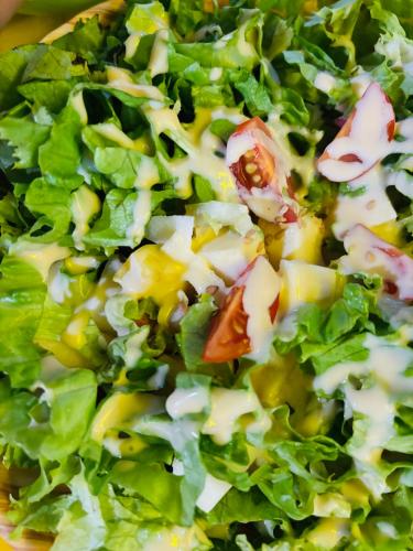 Una ensalada con lechuga y queso en un plato. en lối nhỏ homestay, en Ha Long