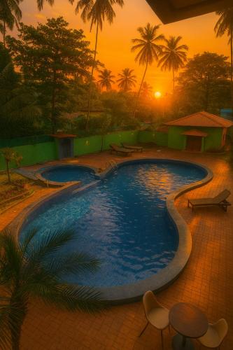 ein großer Pool mit Sonnenuntergang im Hintergrund in der Unterkunft Hotel Shiva Classic, Calangute Beach Goa in Calangute