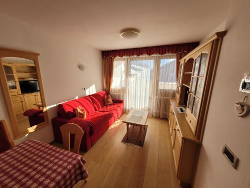 een woonkamer met een rode bank en een raam bij Chalet Milandora in La Villa