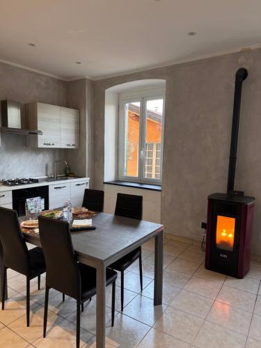 - une cuisine avec une table et un poêle à bois dans l'établissement "Coccole nel borgo" 2min to outlet apartment with terrace, à Serravalle Scrivia