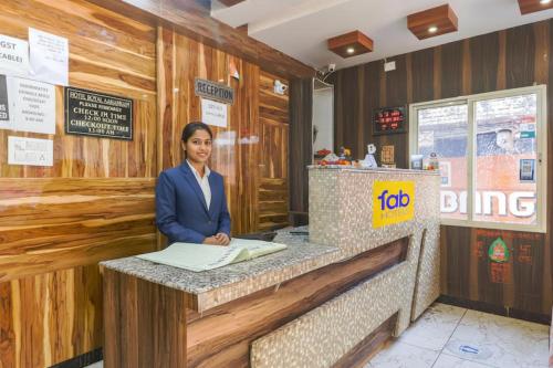 une femme debout à un comptoir dans un restaurant dans l'établissement FabHotel Royal Aanandam, à Gwalior