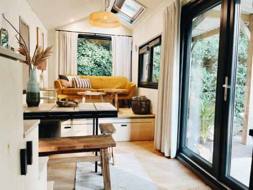 a living room with a couch and a table at Tiny House met privé hottub in Rutten