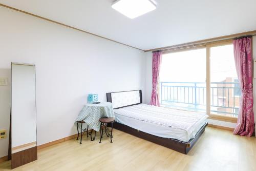 a bedroom with a bed and a table and window at 온담펜션 