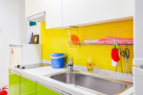 a kitchen with a sink and a yellow wall at 온담펜션 