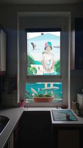 ein Küchenfenster mit einem Bild einer Frau in der Unterkunft Apartman BRKO in Bihać