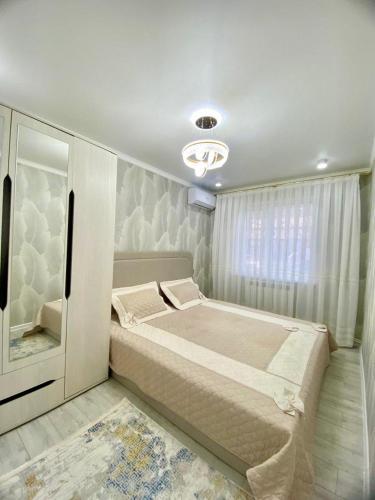 a bedroom with a large bed and a window at Appartament Shymkent in Shymkent