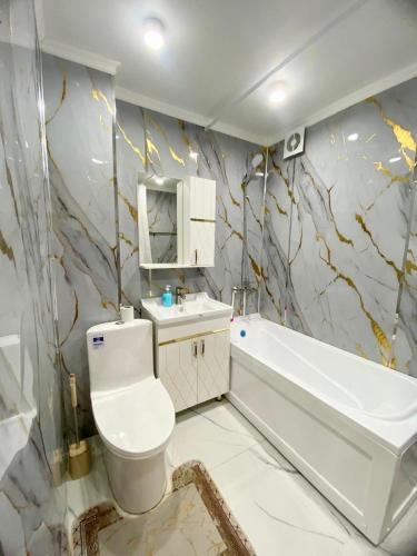 a bathroom with a toilet and a tub and a sink at Appartament Shymkent in Shymkent