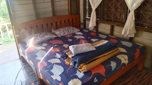 a bed in a room with a cow patterned blanket at Billy the Homestay in Chiang Dao