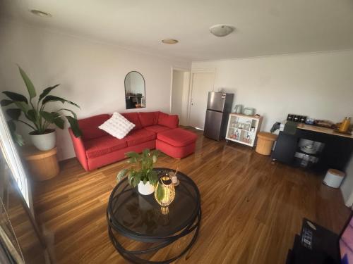 Taylors LakesにあるThe Welcome Innの赤いソファとテーブルのあるリビングルーム