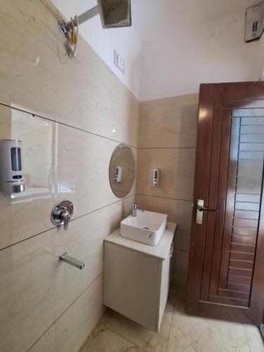 Un baño con lavabo, inodoro y espejo. en Castle INN Hotel, en Rājpur