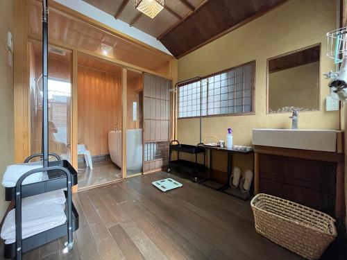 um quarto com uma casa de banho com um lavatório e uma banheira em 古民家宿 禅楽 em Shimminato