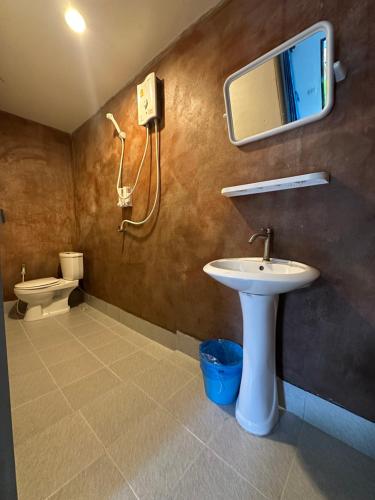une salle de bain avec un lavabo et un miroir et des toilettes dans l'établissement Lanta bluewave Bungkalow, à Phra Ae beach