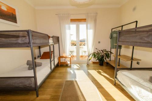 ein Zimmer mit drei Etagenbetten und einem Fenster in der Unterkunft Surf Lodge Santa Cruz in Silveira
