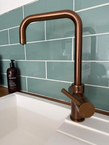 a kitchen sink with a copper faucet at The Little Fern in Oxford
