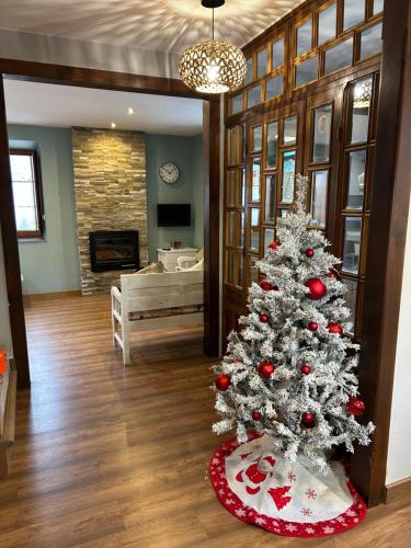 a christmas tree in a living room with a fireplace at La Balconada de Valdeón in Posada de Valdeón