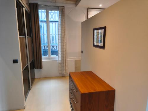 a room with a wooden cabinet and a window at Le Vieux Palais Hypercentre Rouen, Place Vieux Marché - Linge & Ménage Inclus in Rouen