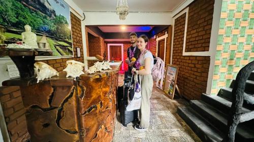 two people standing at a counter in a museum at Sigiri Heritage Villa in Sigiriya