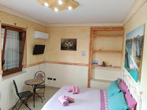 Un dormitorio con una cama y una mesa y sillas. en M'arriposu, en Realmonte