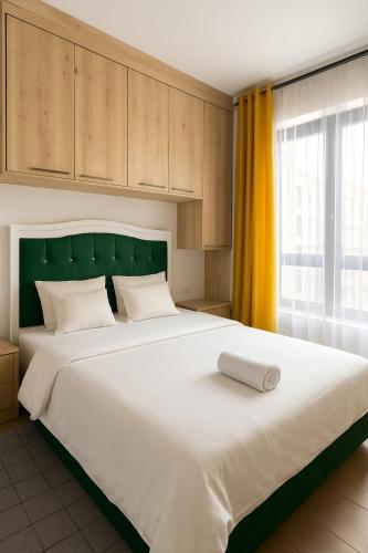 a bedroom with a large white bed with a green headboard at Executive Studio in Kinoo in Rungiri