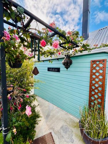 una porta da garage blu con dei fiori sopra di La case d'Édith a Le Tampon