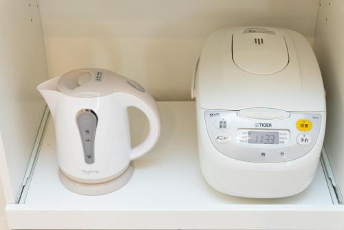 a coffee maker and a blender sitting on a shelf at Miraie Katano Stay in Kisabe