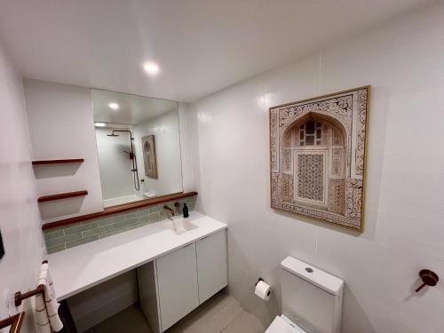 a bathroom with a sink and a mirror and a toilet at Top of Tyne - Peace, Comfort & Local Connection in Oamaru
