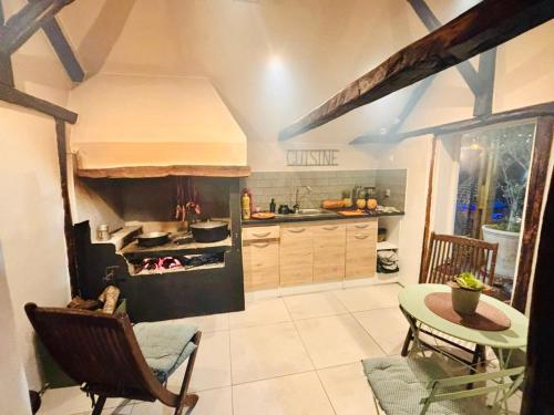 a kitchen with a stove and a table with chairs at La case d'Édith in Le Tampon