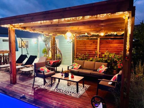 a deck with a couch and chairs and a table at La case d'Édith in Le Tampon