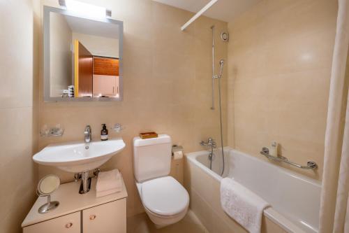 a bathroom with a sink and a toilet and a bath tub at Studio PEAK fantastic view in Zermatt