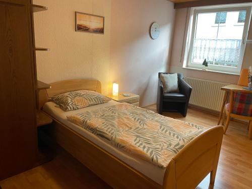 a small bedroom with a bed and a chair at Appartement an der Steinach in Nagold