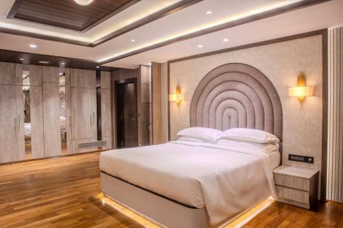 ein Schlafzimmer mit einem großen Bett mit Wandbild in der Unterkunft Pinnacle Residences, Kathmandu in Kathmandu