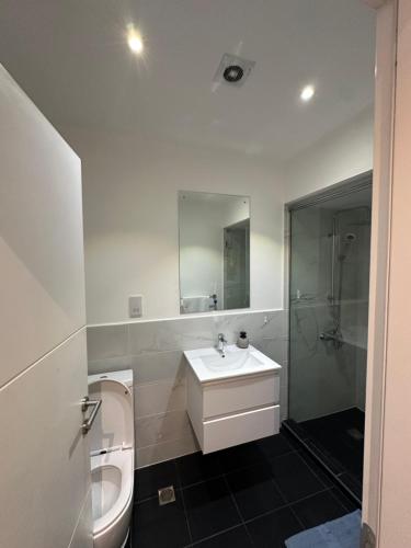 Un baño blanco con lavabo e inodoro. en Peravi Suites At Embassy Gardens, en Trofwi