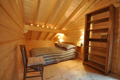 Cette chambre comprend un lit dans une cabane en bois. dans l'établissement Grand Chalet au Praz de Lys, à Taninges