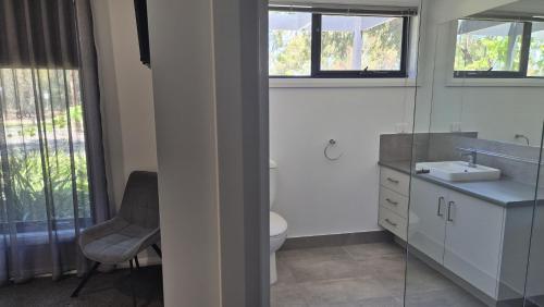 a bathroom with a toilet and a sink and a mirror at Silverwood 17th Hole Retreat in Yarrawonga