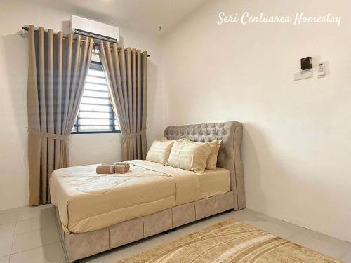 En eller flere senge i et værelse på Seri Centuarea Homestay, Seri Iskandar