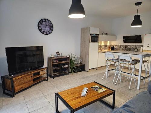 un salon avec une télévision et une table dans l'établissement O'Sables, à Les Sables-dʼOlonne