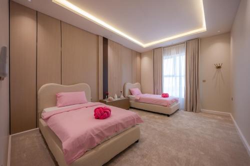 two beds in a room with pink sheets at شقة فاخرة بثلاث غرف نوم دخول ذكي وموقف خاص in Jeddah