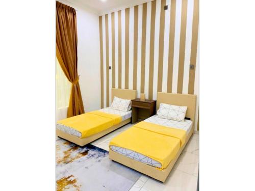 une chambre avec deux lits et une table dans l'établissement Hijrah De La Villa Parit Buntar Nibong Tebal Penang, à Nibung Tebal