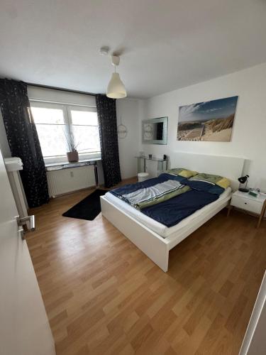 ein Schlafzimmer mit einem Bett und einem Holzboden in der Unterkunft Wolke13 - gemütliche 2 Zimmer Wohnung mit voll ausgestatteter Küche in der City von Menden in Menden