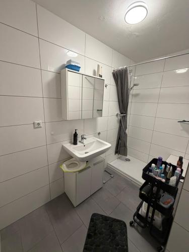 ein weißes Badezimmer mit Waschbecken und Toilette in der Unterkunft Wolke13 - gemütliche 2 Zimmer Wohnung mit voll ausgestatteter Küche in der City von Menden in Menden