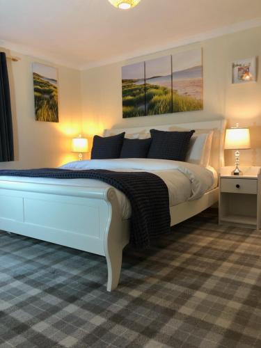 a bedroom with a large bed with three paintings on the wall at Old School B&B Super King Exclusive 5 Room private suite in Orkney