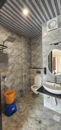 a bathroom with a sink and a toilet and a mirror at Pratap Royal Stay in Ujjain