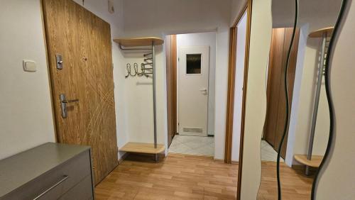 une salle de bain avec un couloir avec une porte et un miroir dans l'établissement M przy Broniewskiego, à Łomża