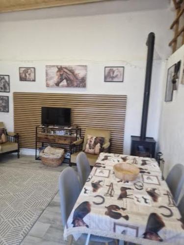a dining room with a table and chairs and a television at Casa Fernando Casquinha in Vila Franca de Xira