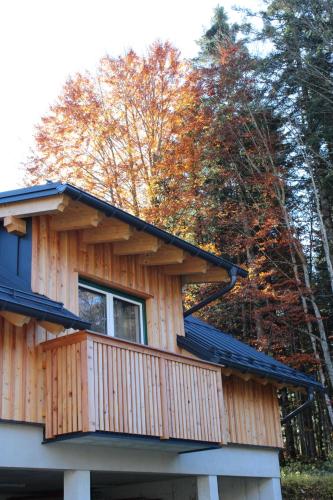 a log cabin with a balcony in the woods at Panorama Loft Bad Aussee in Bad Aussee