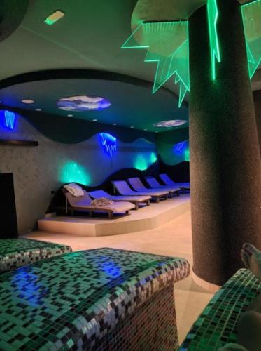 a room with two beds and purple and green lights at Milmari apartman SAN-28 in Kopaonik